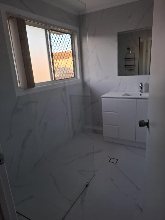 Completed bathroom in white marble with walk-in shower